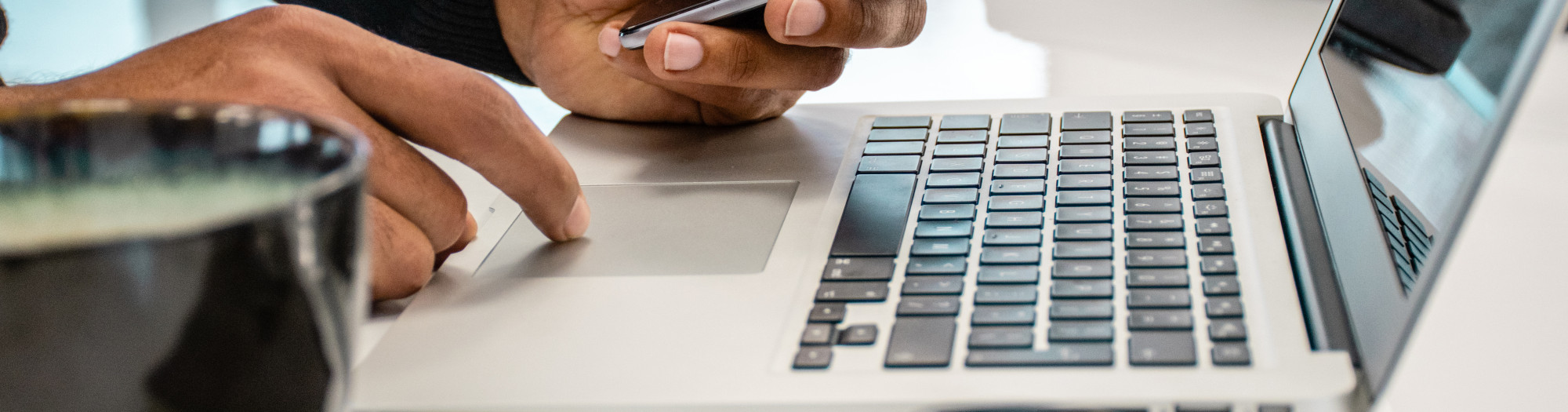 Man using laptop and mobile phone on desk