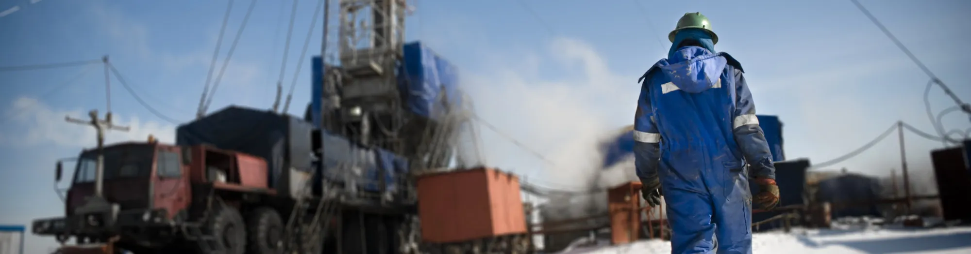 Male in blue jumpsuit at construction site in the snow