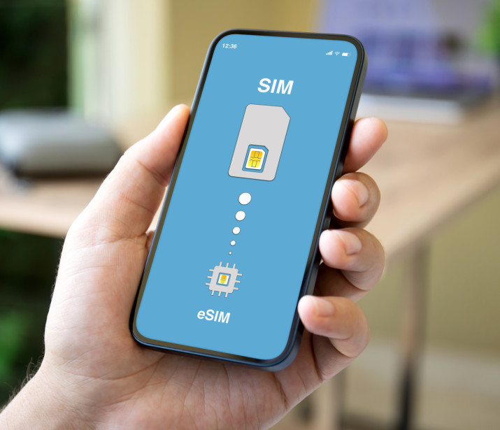 Man holding a phone with eSIM replacement