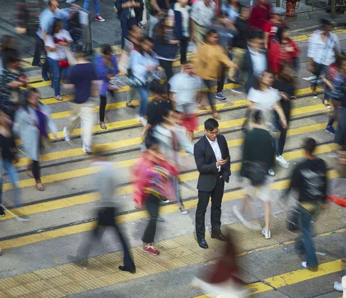 Business man in crowd using mobile phone