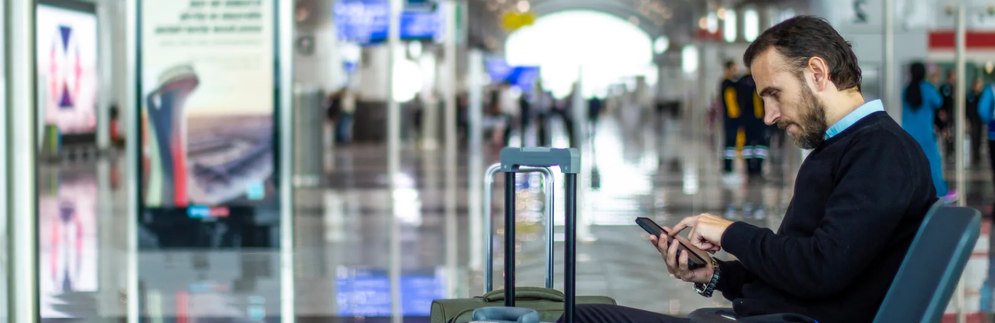 Male worker at airport using his phone